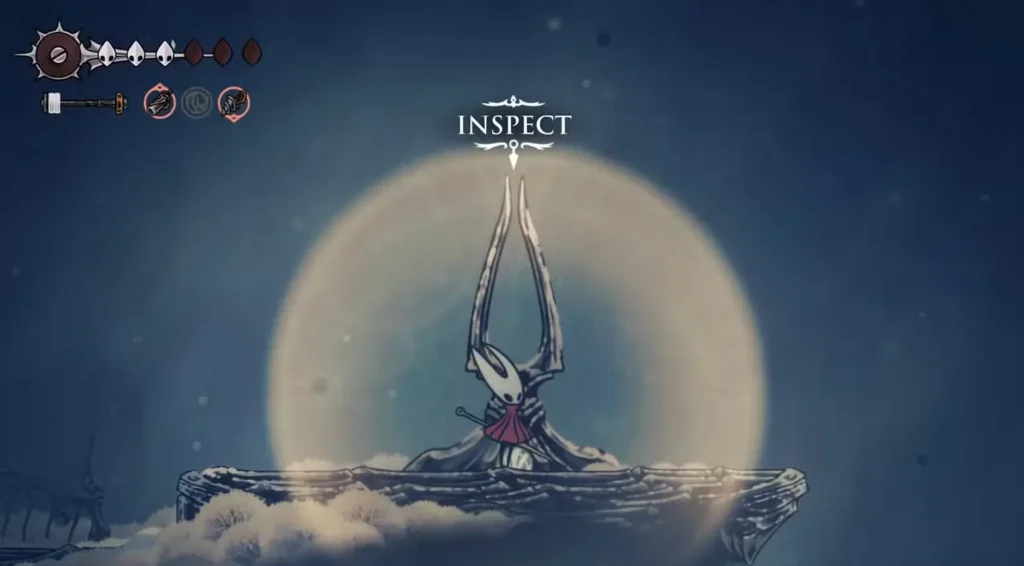 Hornet stands in the mystical Memorium chamber with glowing orb and "INSPECT" prompt displayed above